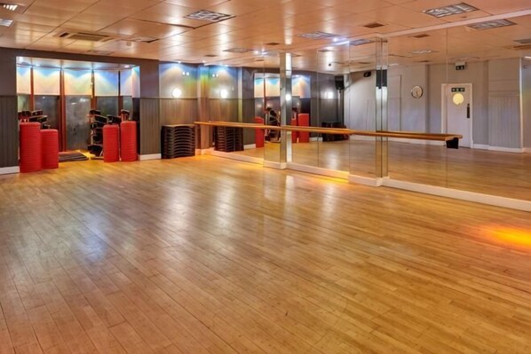 A spacious dance studio with a wooden floor, a large mirror, and a barre. - Holiday Inn GLASGOW - EAST KILBRIDE by IHG (East Kilbride)