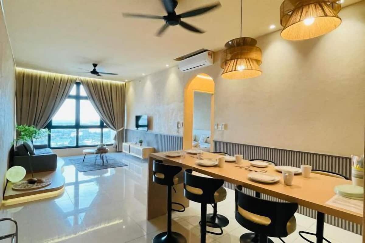 A modern dining area with a long table, bar stools, ceiling fans, and pendant lighting.