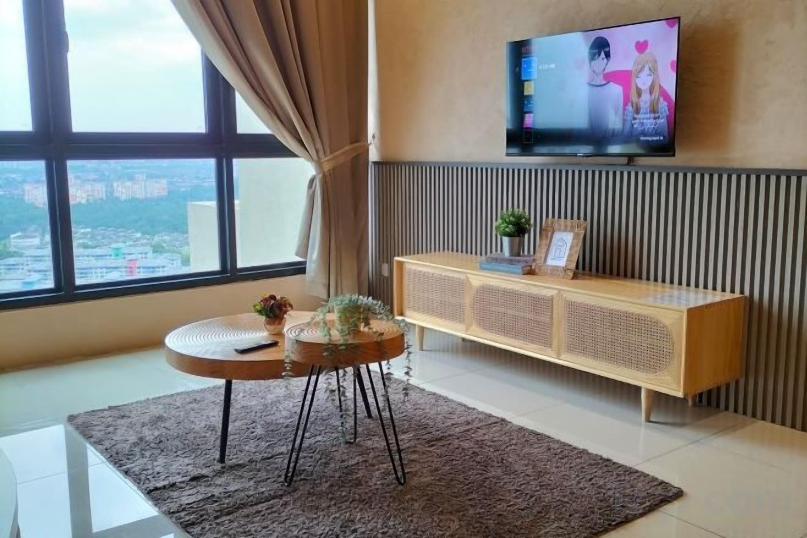 A modern living room with a large window, a flat-screen TV, a round coffee table, and a wooden console table.