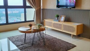 A modern living room with a large window, a flat-screen TV, a round coffee table, and a wooden cabinet. - L23-ParadigmMall Residence Skudai JB 3R2B-10pax (Tebrau)