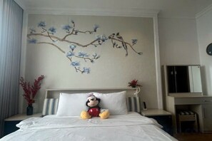 A hotel room with a bed, a decorative branch painting, a nightstand, and a mirror. - Cozy Homestay 2 BR sea view 29th flr Halong center. (Ha Long)