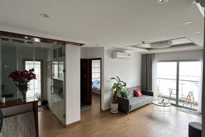 Uma sala de estar moderna com sofá, mesa de centro e uma janela grande.