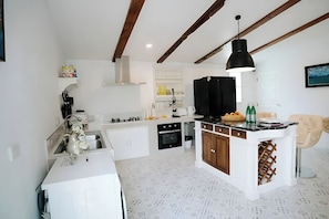Una cocina moderna con armarios blancos, una isla central y una lámpara colgante.