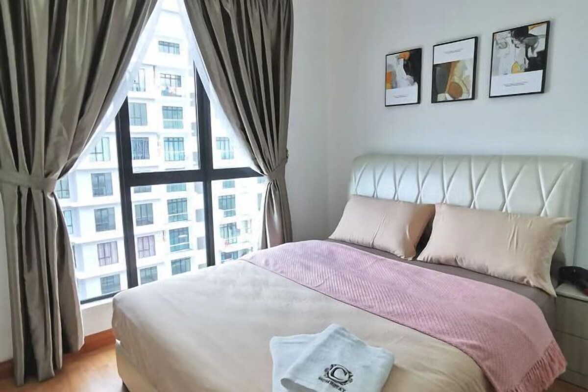 Een hotelkamer met een groot raam, een bed met een wit hoofdeinde en drie ingelijste foto's aan de muur.