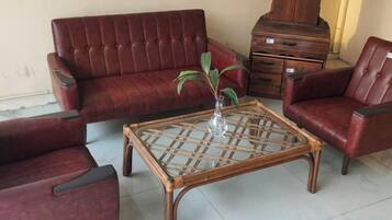 Ein Zimmer mit einem roten Sofa, einem Glastisch und einer Holzkabine.