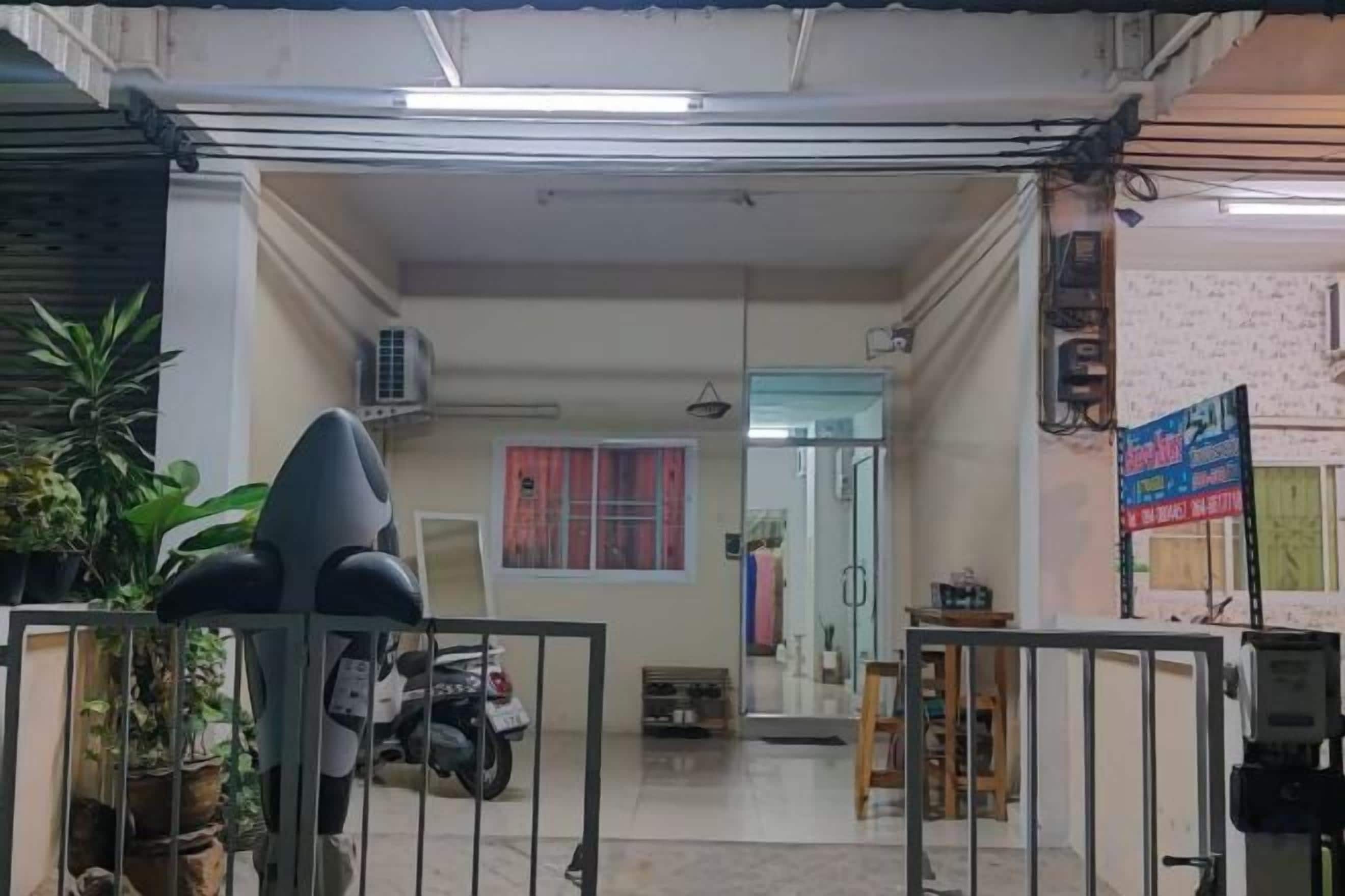 Un espacio interior con una reja, una motocicleta y una planta en maceta.