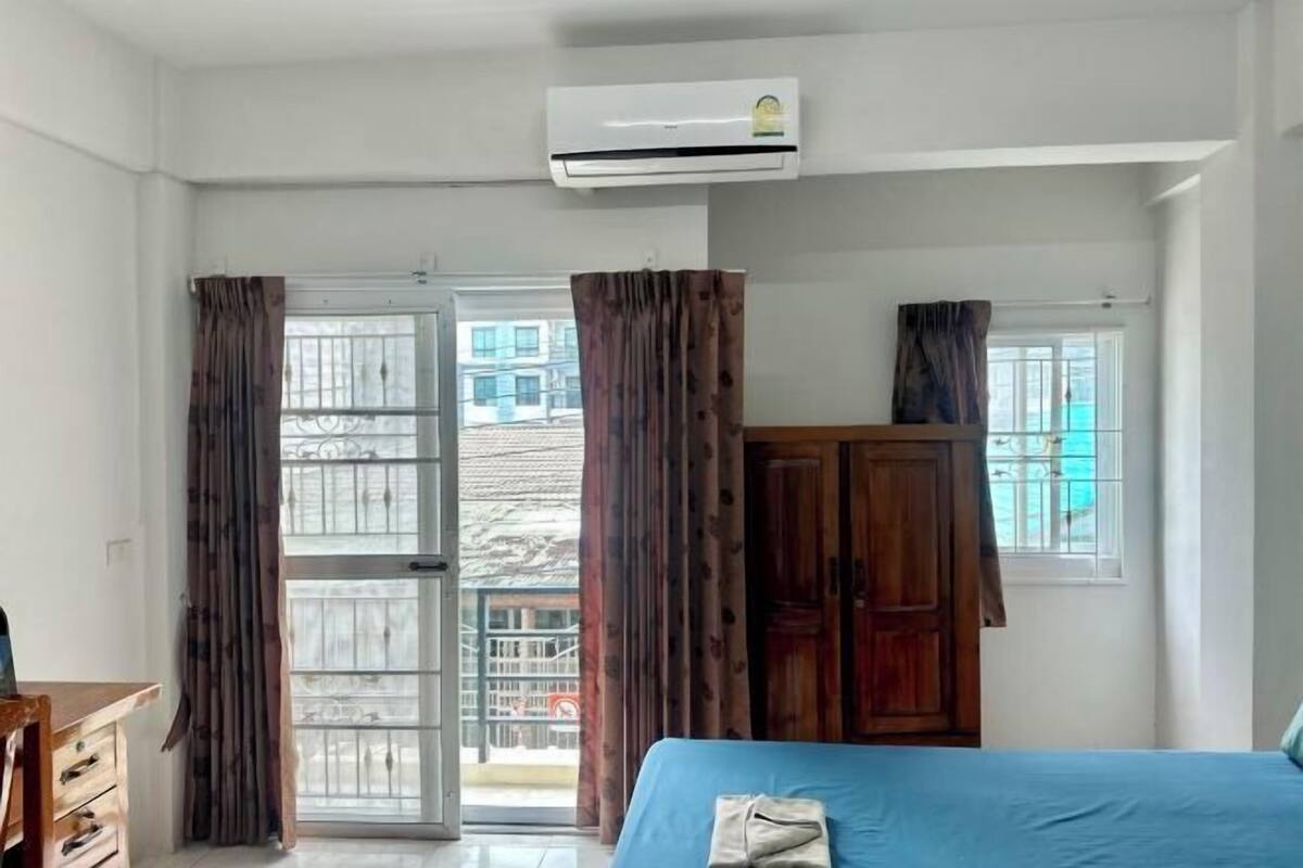 Una camera da letto con un letto, un condizionatore d'aria, un armadio e vista panoramica tramite una porta in vetro.