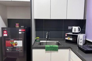 A modern kitchen with a refrigerator, microwave, and sink. - SKS Habitat Larkin@2Bed 3 min to Larkin Central (Johor Bahru)