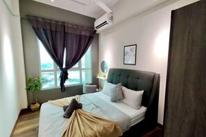 Un dormitorio con cama, ventana con cortinas, planta en maceta, mesita de noche y aire acondicionado instalado en la pared.