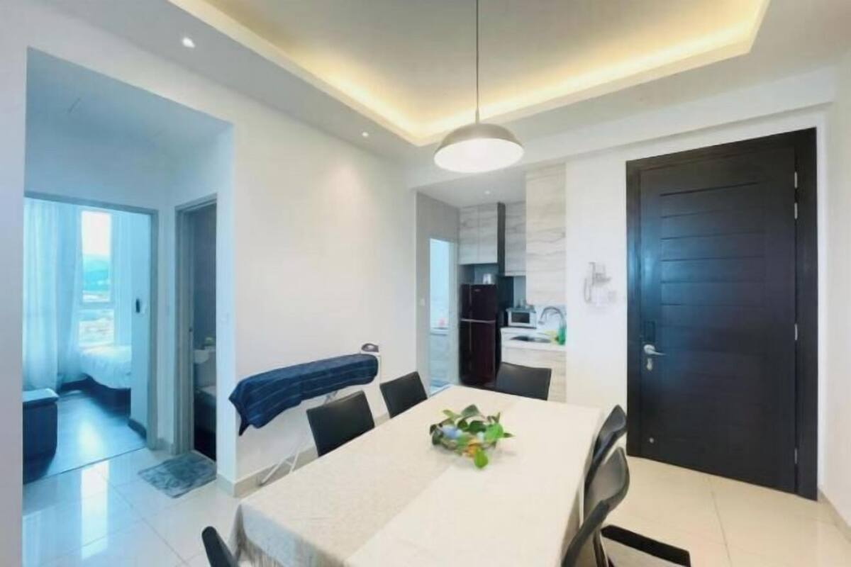 Uma área de jantar moderna com mesa, cadeiras e luminária pendente.