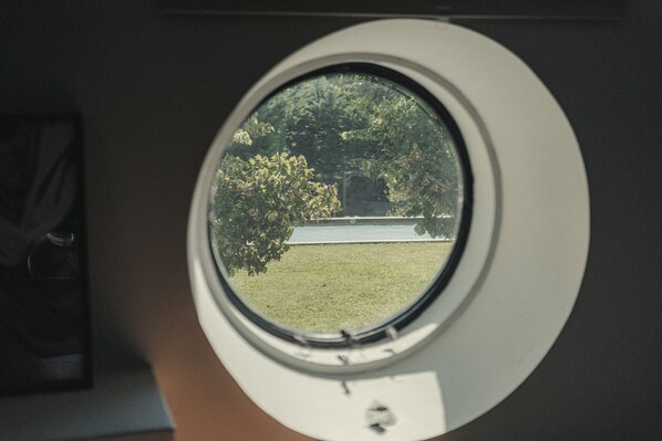 A window with a view of a grassy area and trees.