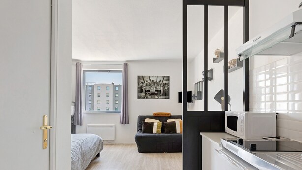 A compact room with a bed, a sofa, a microwave, and a refrigerator. - Apartment 'L'aventurier' – Steps from Futuroscope, Sleeps 4 (chasseneuil du Poitou)