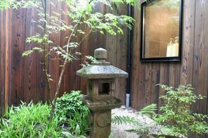 A stone lantern, a wooden fence, and a window with a candle inside. - Kin · Tengachaya 12-3 (Osaka)