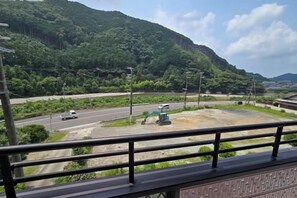 Une autoroute avec des glissières de sécurité, un carrefour et une chaîne de montagnes en arrière-plan.
