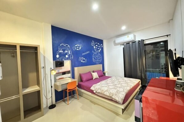 A bedroom with a bed, a desk, a chair, a wardrobe, and a window with curtains.
