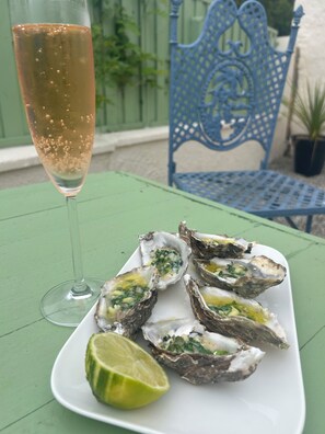 A plate of oysters with a lime wedge, a glass of champagne, and a blue chair in the background. - A cosy countryside gite with pool, surrounded by nature and near the Pyrenees. (Laroque-d'Olmes)