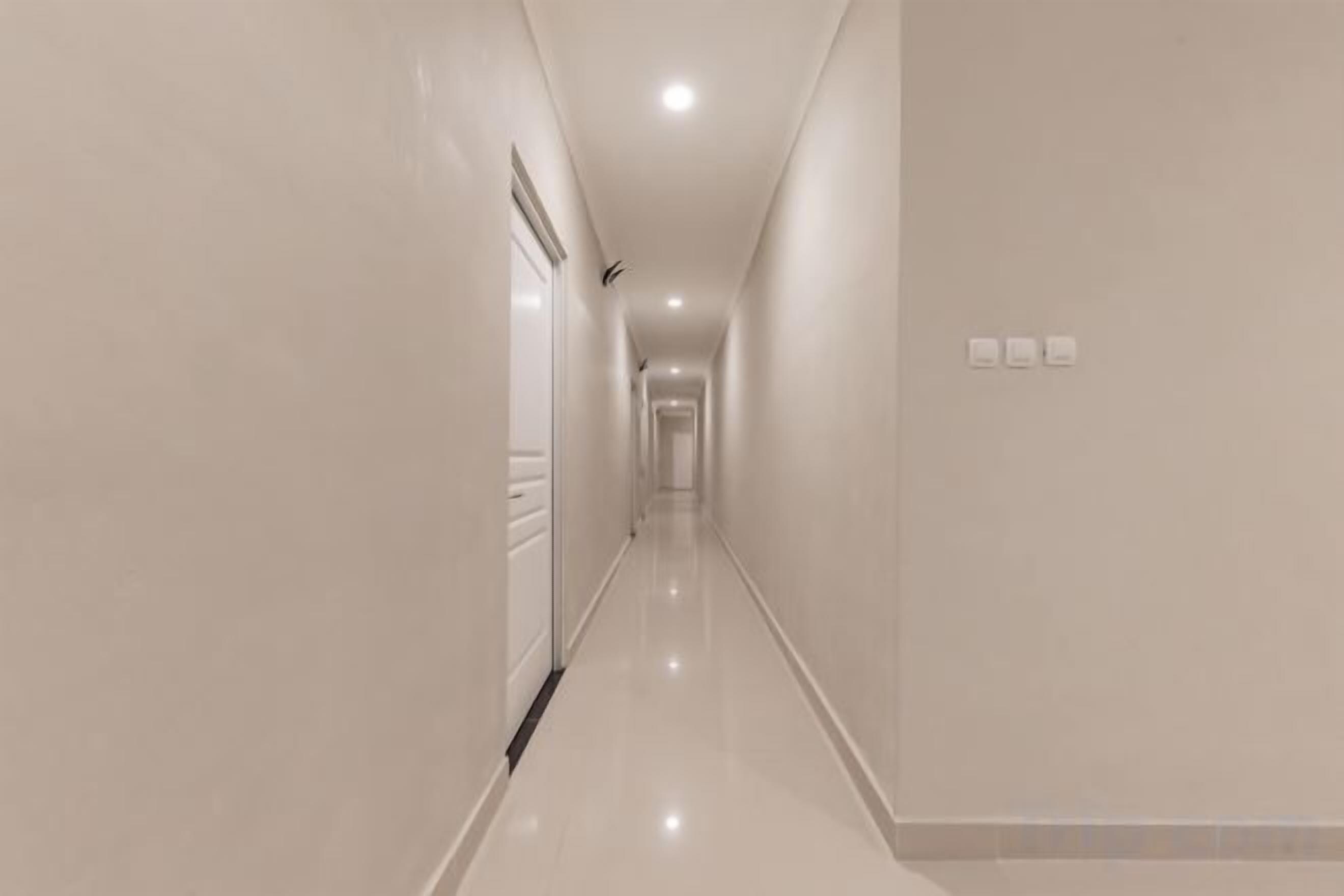 A long, narrow hallway with a glossy floor and light-colored walls.