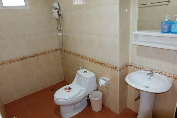 A small bathroom with a toilet, a sink, and a shower.