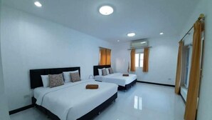 Habitación de hotel con dos camas, ropa de cama blanca y un ventanal con cortinas.