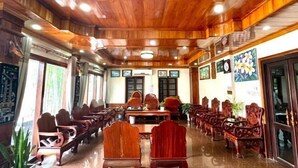 Egy konferenciaterem, melynek falait fapanelek borítják, egy hosszú asztal és több szék található benne.