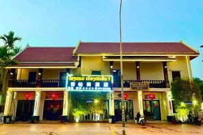 A two-story building with a balcony, a signboard, and a red roof. - Heuangpaseuth Hotel (Luang Prabang)