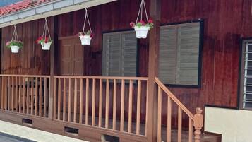 A wooden building with a balcony, hanging flower baskets, and a staircase.
