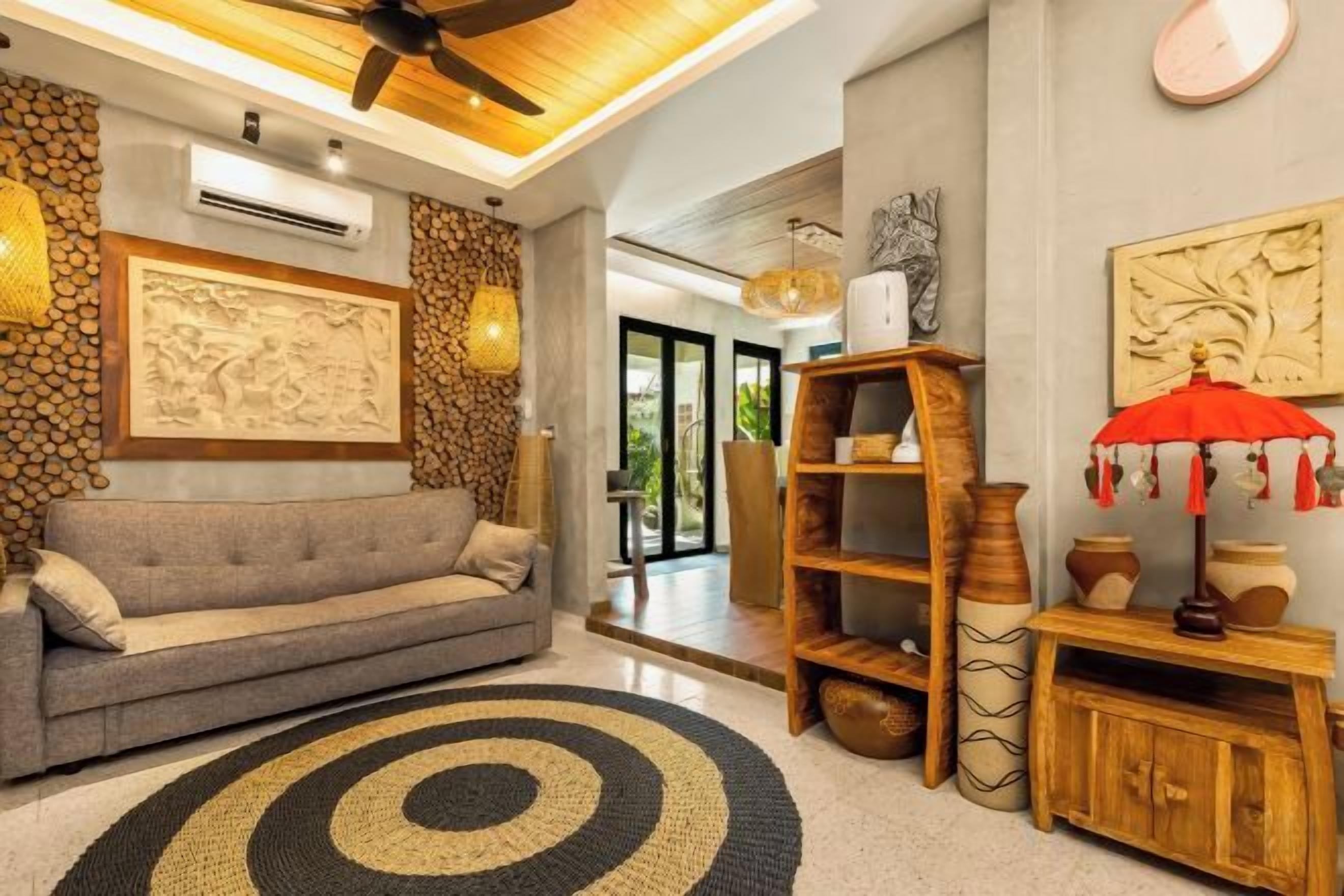 A living room with a sofa, a coffee table, a bookshelf, and a red umbrella.