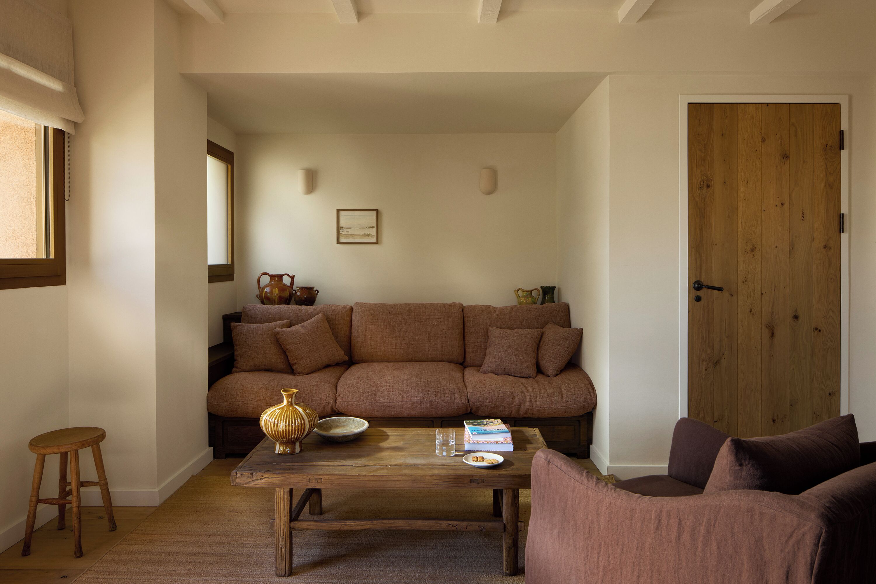 A living room with a sofa, a coffee table, and a door.