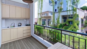 A balcony with a view of residential buildings, a hanging light fixture, and a wooden floor. - Cozrum Homes - Yoga Corner (Ho Chi Minh City)