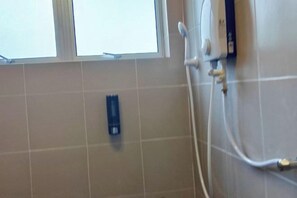 A bathroom with a window, a towel dispenser, and a shower control panel. - Forget-Me-Not Pangkor Homestay 70 (Pangkor)