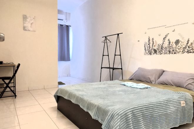 Un dormitorio con una cama, un escritorio y una silla.