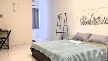 Un dormitorio con una cama, un escritorio y una silla.
