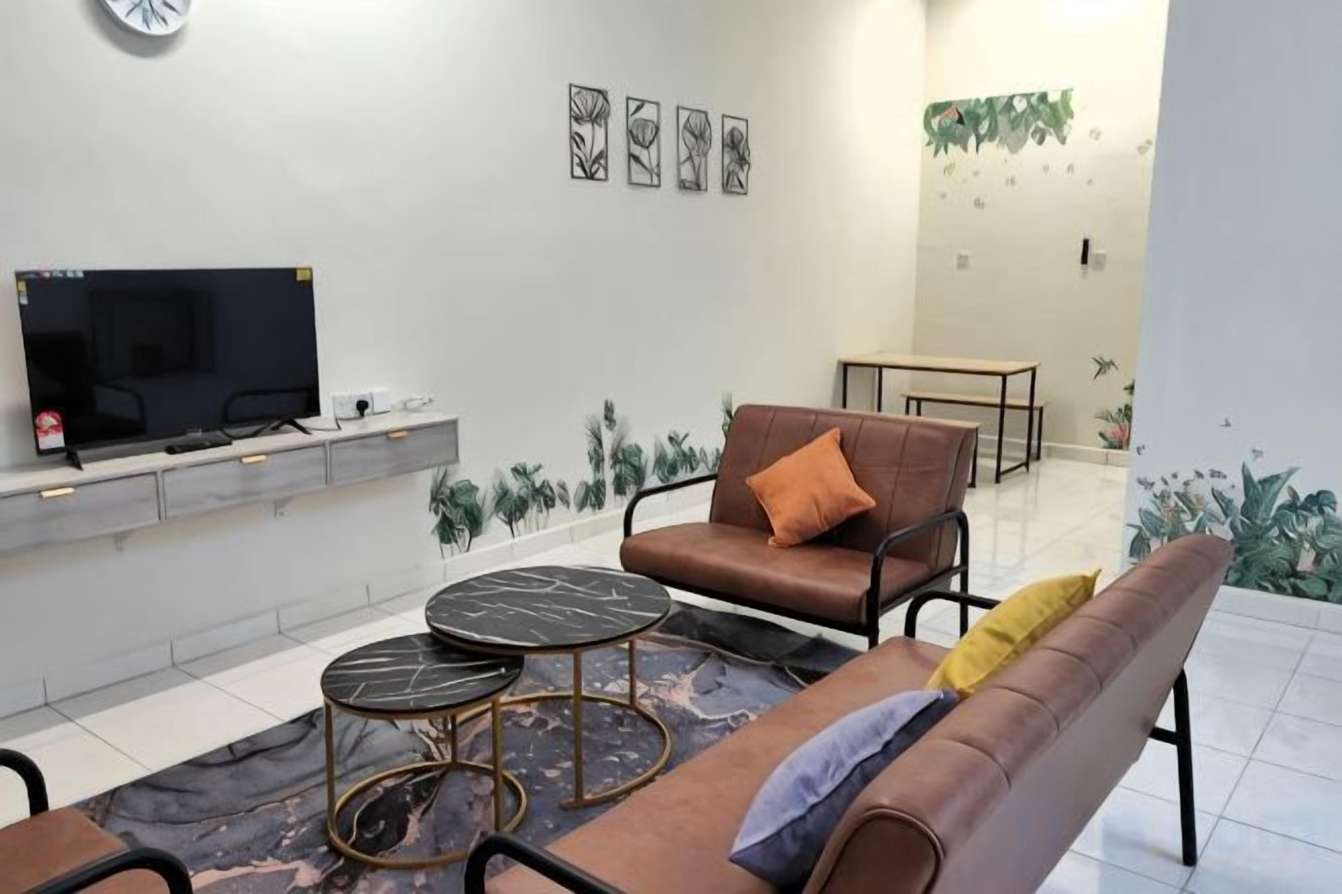 Una sala de estar con sofá, mesa de centro, televisor y plantas decorativas.