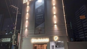 The exterior of the Den Basta hotel with a prominent sign indicating a grand opening. - Masan Den Basta hotel Gyeongnam Uni (Changwon)