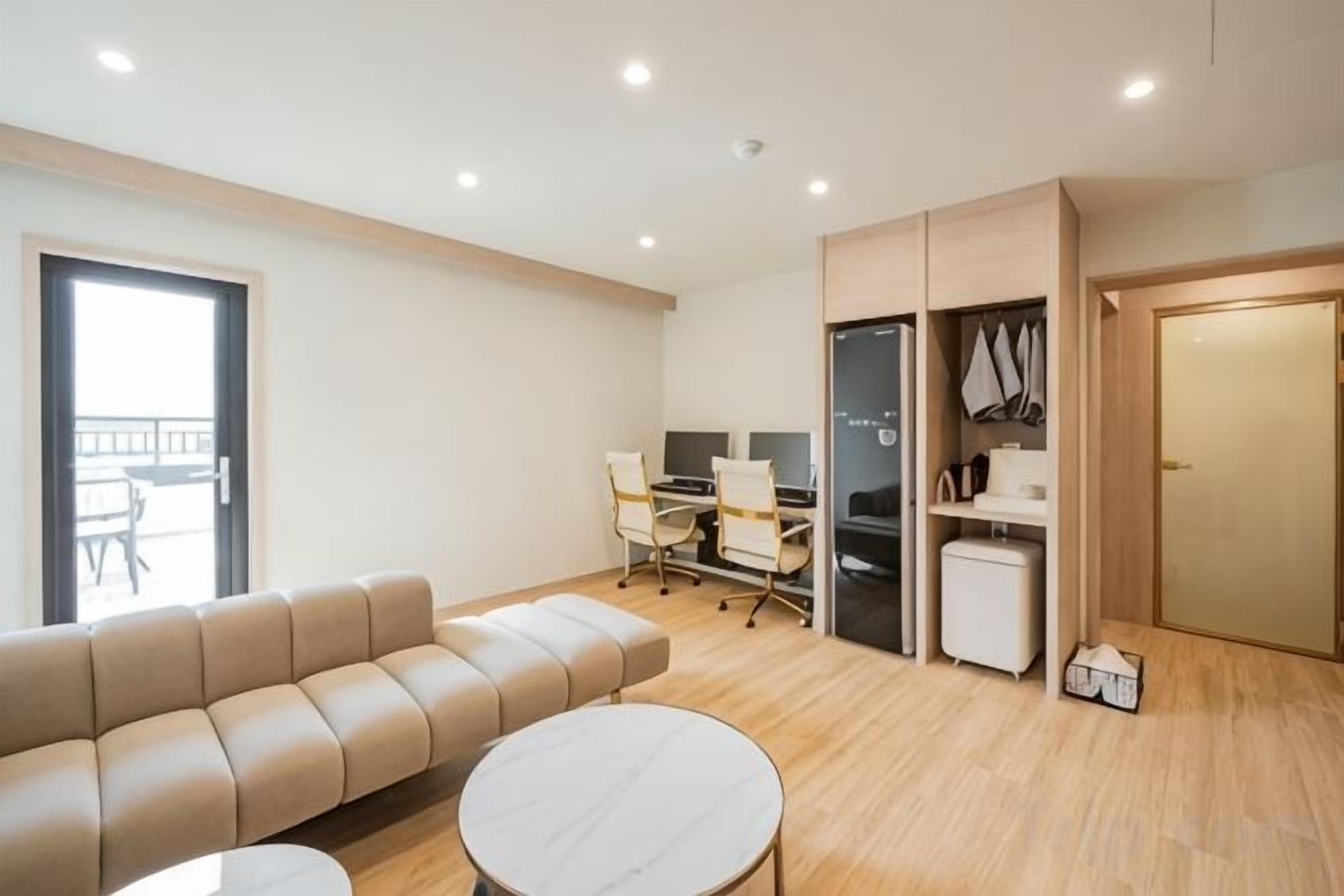 Una sala moderna con sofá, una mesita redonda y un comedor con sillas y una mesa.