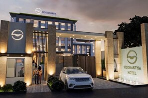 A hotel entrance with a modern design, a car parked in front, and a signboard displaying the hotel name. - Siddhartha Vilasa, Bhairahawa (Rupandehi)