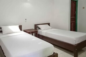 Two single beds with wooden frames and white linens in a room with a tiled floor and a green door. - Daton House Near Bali Zoo Ubud Mitra RedDoorz (Bali)