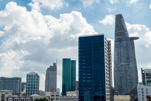 A cityscape with modern high-rise buildings and a distinctive curved skyscraper. - Ohana Hotel - Near Bitexco (Ho Chi Minh City)
