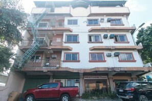 Un edificio de varios pisos con entrada a nivel de calle, una escalera visible y un letrero que dice 'WESTVIEW'.