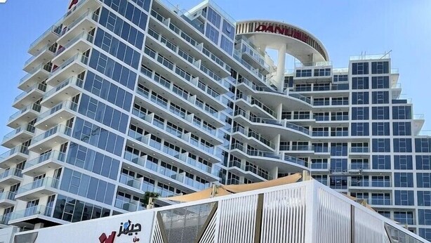 A multi-story hotel with a distinctive curved top and balconies. - SIMPLY COMFORT Chic 3 Br Apartment with Private Pool (Dubai)