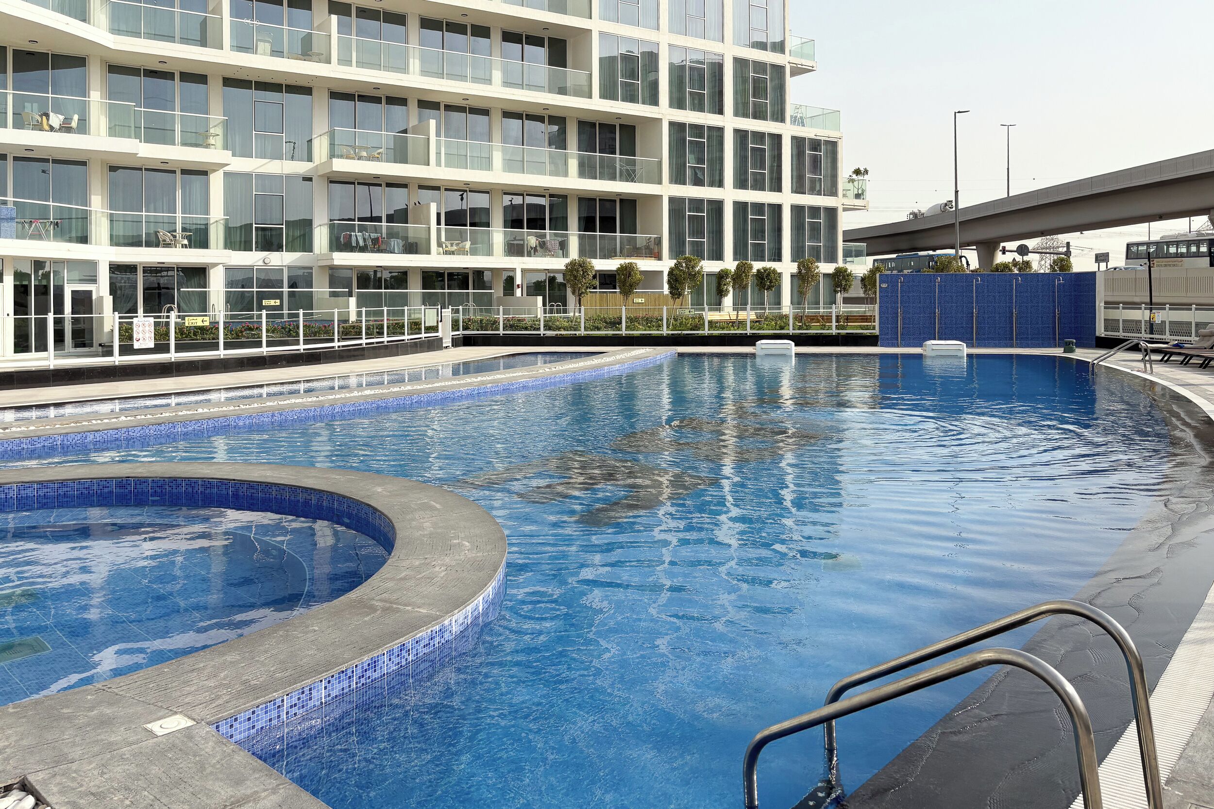 Un hôtel moderne doté d’une grande piscine intérieure, d’un bâtiment à plusieurs étages et offrant une vue sur un pont.