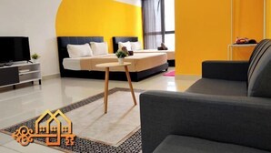 Ein modernes Hotelzimmer mit einem großen Bett, einem Fernseher und einem Sofa.
