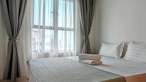 Ein Hotelzimmer mit Bett, Vorhängen und einem Fenster.