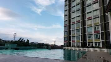 A high-rise building with a swimming pool in the foreground.