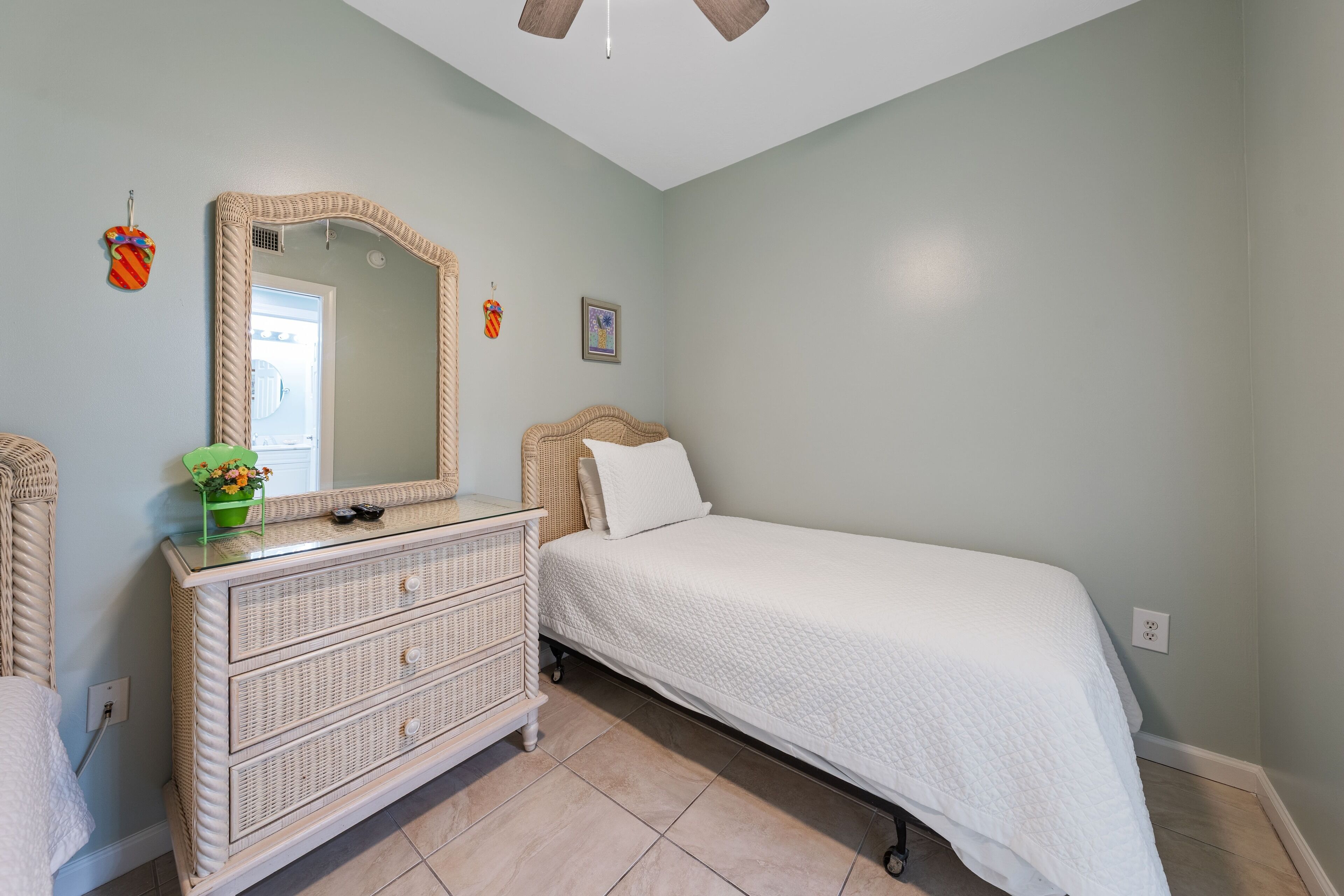 A bedroom with a bed, a dresser, a mirror, and a door.