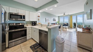 A modern kitchen with stainless steel appliances, a dishwasher, and a large island with a sink.