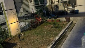 A garden area with a bicycle, a water feature, and a metal fence. - Fallem's Homestay I 4 Rooms I Fully Aircond I WiFi (Melaka)