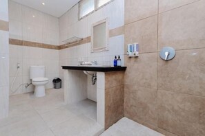 Een badkamer met toilet, wastafel, spiegel en handdoekhouder.