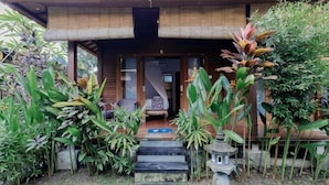 A house with a wooden exterior, a front porch, and a staircase leading to the entrance. - The Lavana Jhonny Kibung Villas Lembongan (Bali)