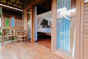 A wooden room with a bed, a table, and chairs.